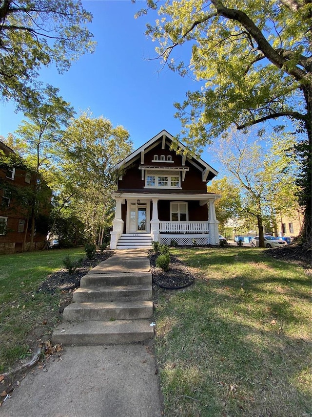 view of front of property featuring covered porch and a front lawn