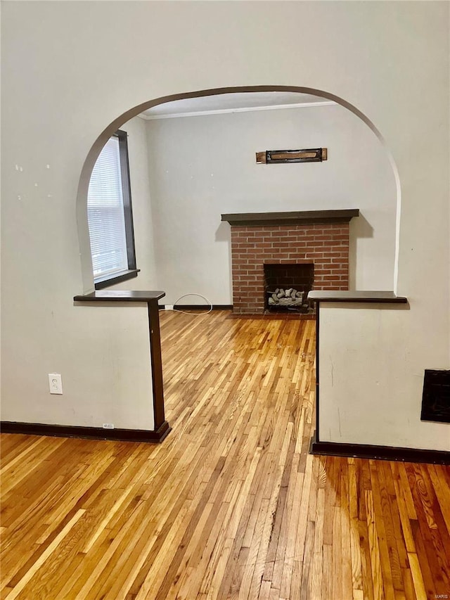 unfurnished living room with light wood-type flooring and a fireplace