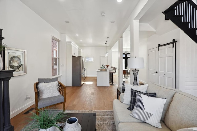 living room with wood-type flooring and a barn door