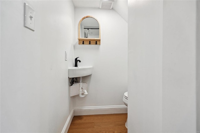 bathroom with sink, hardwood / wood-style floors, and toilet