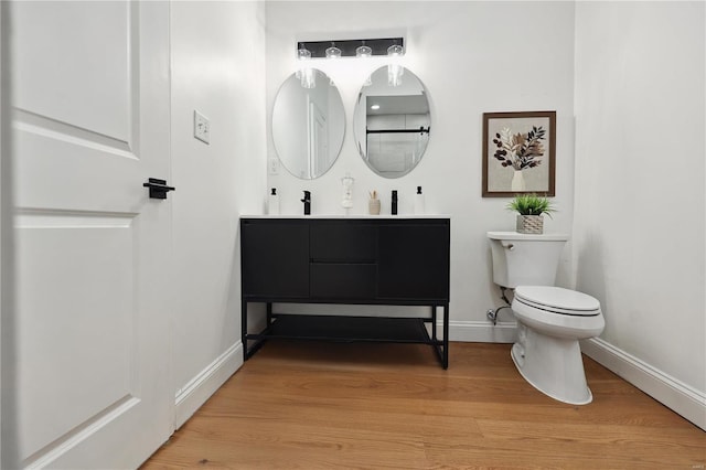 bathroom featuring vanity, hardwood / wood-style floors, and toilet