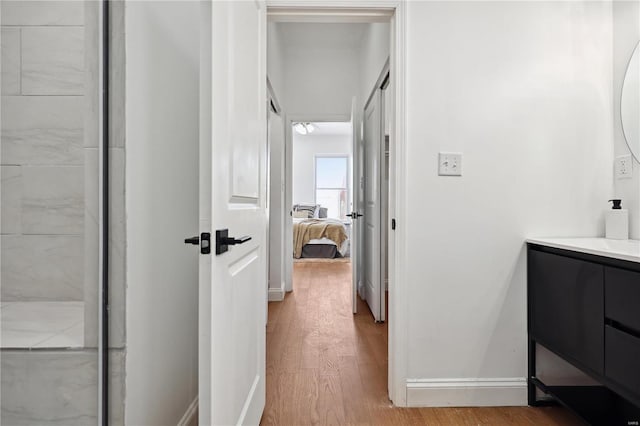 bathroom with wood-type flooring, a shower, and vanity