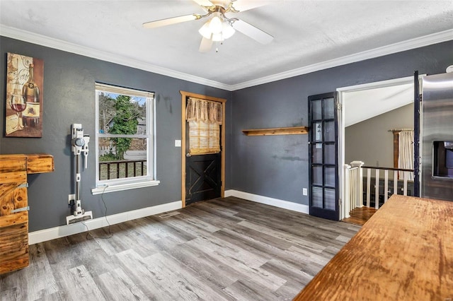 entrance foyer featuring ceiling fan, wood-type flooring, crown molding, and lofted ceiling