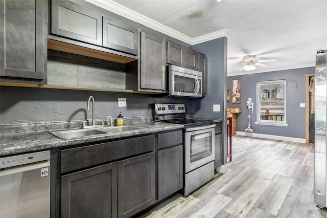 kitchen featuring ornamental molding, dark brown cabinets, stainless steel appliances, ceiling fan, and sink