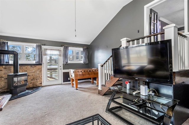 carpeted living room with a wood stove and lofted ceiling