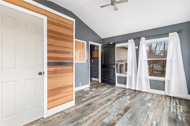 spare room with ceiling fan, dark wood-type flooring, and lofted ceiling