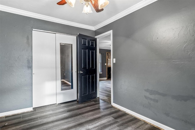 unfurnished bedroom with ceiling fan, a closet, dark hardwood / wood-style floors, and ornamental molding