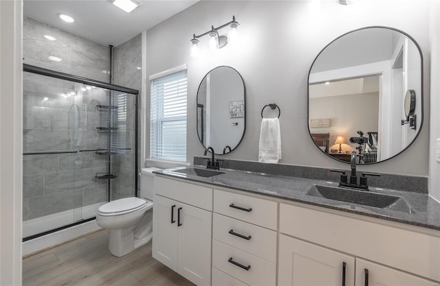 full bathroom featuring toilet, a stall shower, and a sink