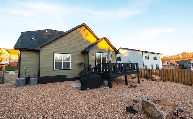 rear view of house featuring central air condition unit, a deck, and fence