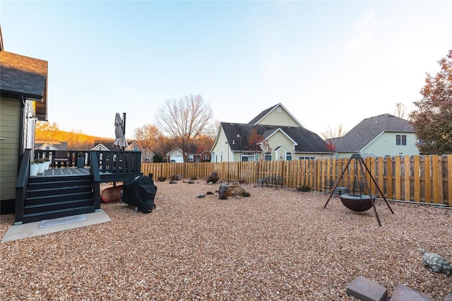 view of yard with a deck, a playground, and a fenced backyard