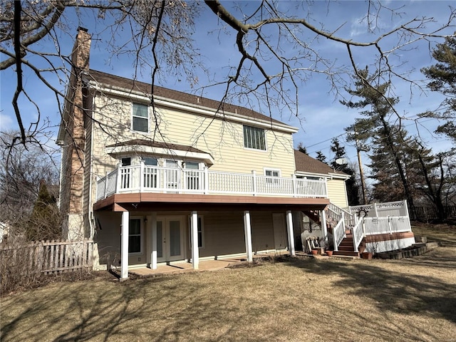 back of house featuring a deck and a lawn