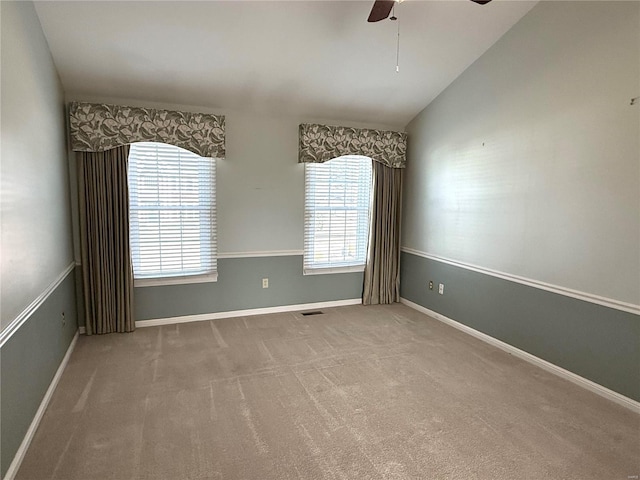 spare room with lofted ceiling, light colored carpet, and ceiling fan