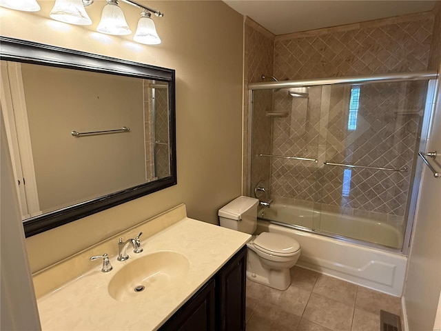 full bathroom with tile patterned flooring, vanity, bath / shower combo with glass door, and toilet