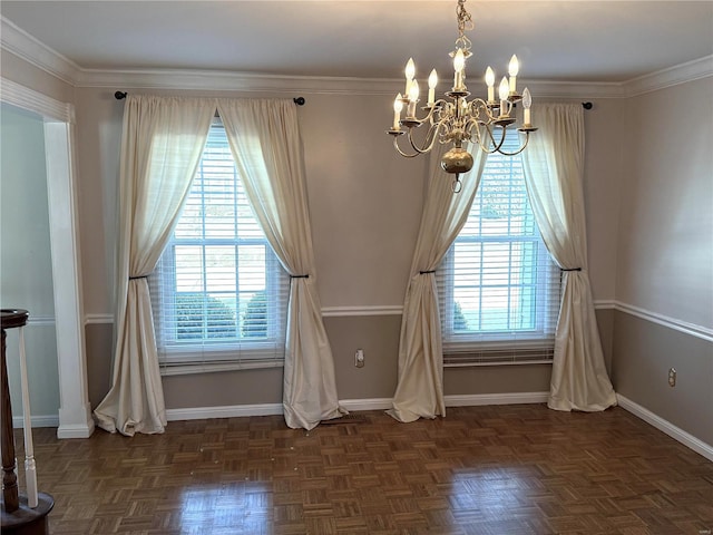 interior space with ornamental molding, plenty of natural light, an inviting chandelier, and dark parquet floors