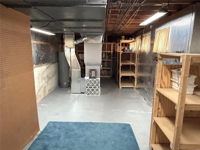 basement featuring heating unit and water heater