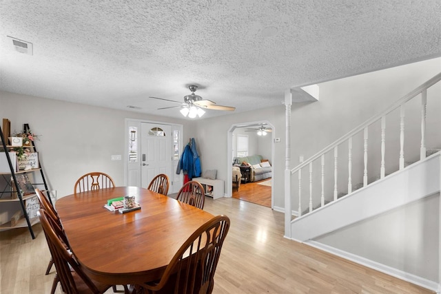 dining room featuring a textured ceiling, light hardwood / wood-style flooring, and ceiling fan