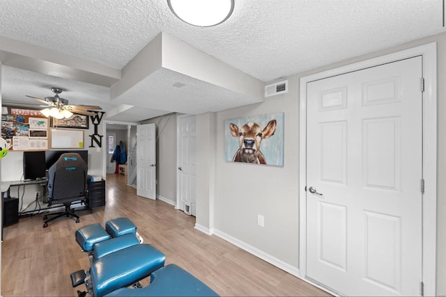 office area featuring wood-type flooring, a textured ceiling, and ceiling fan