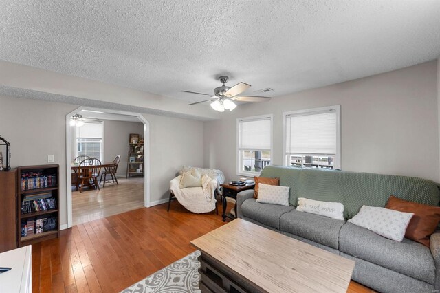 living room with wood-type flooring, a textured ceiling, and ceiling fan