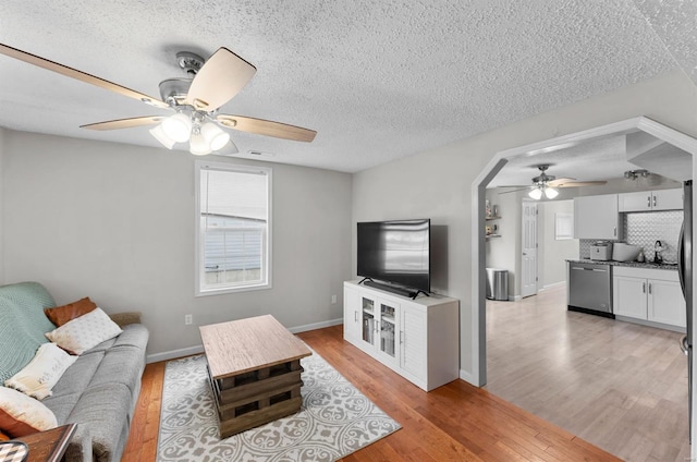 living room featuring light hardwood / wood-style flooring, a textured ceiling, and sink