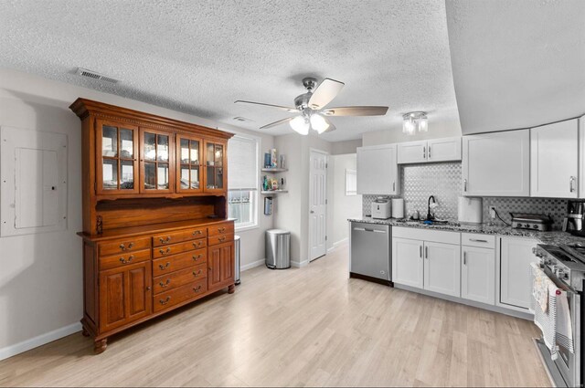 kitchen featuring white cabinets, light stone counters, stainless steel appliances, and tasteful backsplash