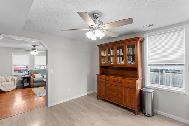 dining area featuring ceiling fan, a textured ceiling, and light hardwood / wood-style flooring