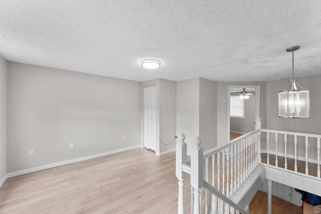 unfurnished room featuring ceiling fan, light hardwood / wood-style flooring, and a textured ceiling