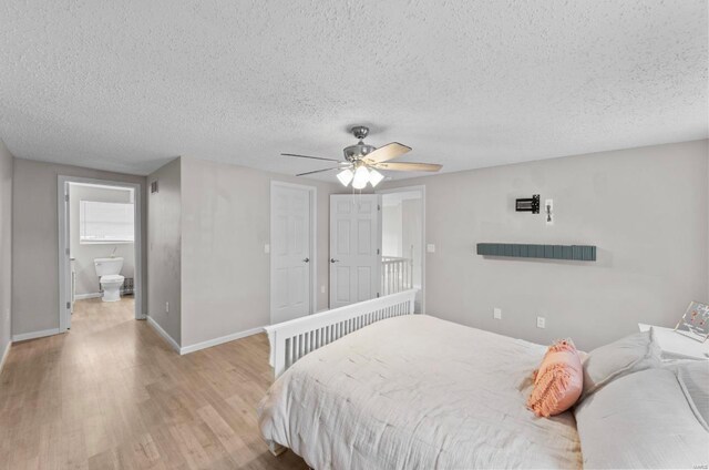 bedroom featuring a textured ceiling, light wood-type flooring, ceiling fan, and connected bathroom