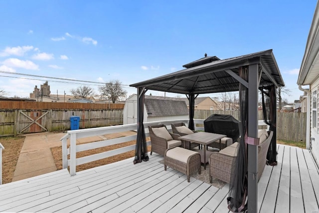 wooden terrace featuring a gazebo, a shed, and a grill