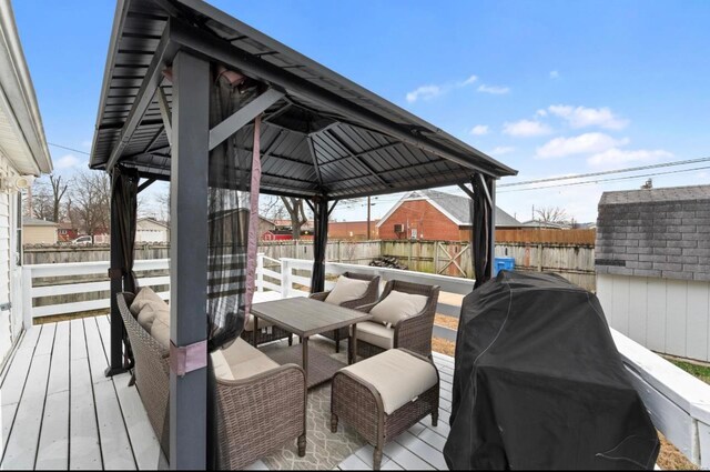 wooden terrace with a gazebo, area for grilling, and a storage unit