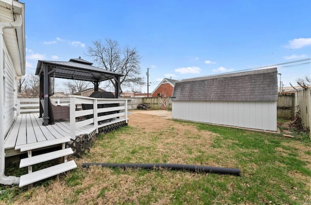 view of yard featuring a gazebo, a storage shed, and a deck