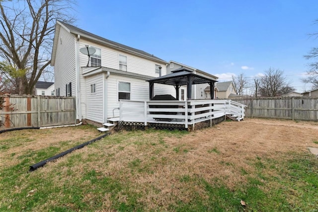 back of property featuring a gazebo, a deck, and a lawn