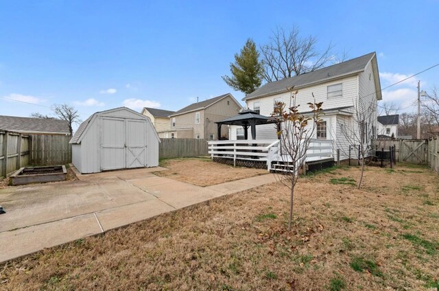 back of house with a gazebo, a shed, a deck, and a yard