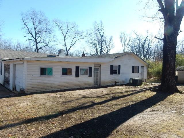 back of house featuring a garage and central air condition unit