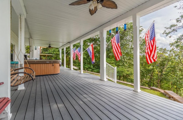 wooden deck with ceiling fan, a porch, and a hot tub