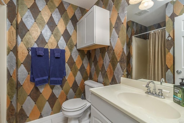 bathroom featuring vanity, toilet, and walk in shower