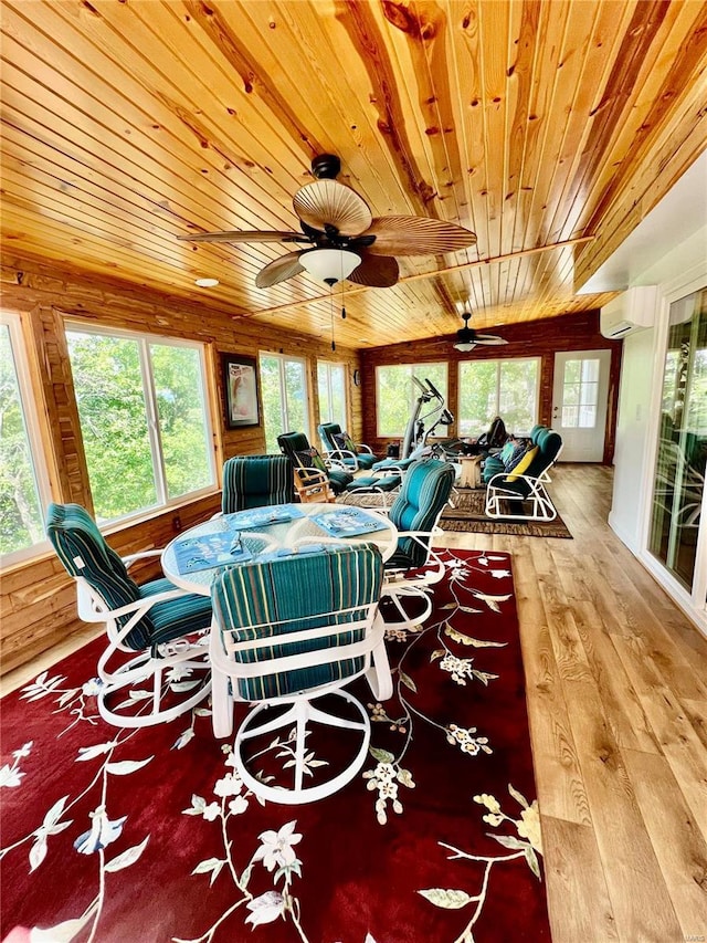 sunroom featuring a wall unit AC, plenty of natural light, and wood ceiling