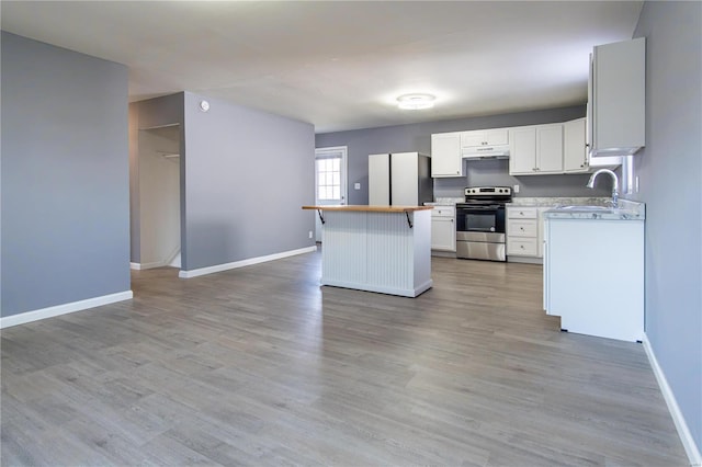 kitchen with stainless steel range with electric cooktop, sink, light hardwood / wood-style flooring, fridge, and white cabinetry