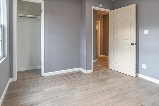 unfurnished bedroom with light hardwood / wood-style flooring and a closet