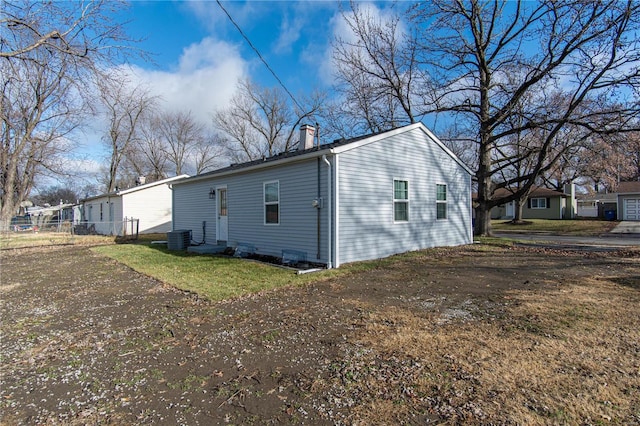 view of property exterior with a lawn and central air condition unit