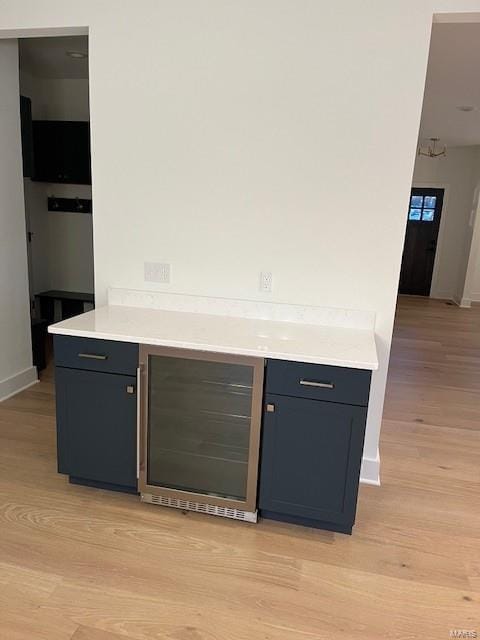 bar featuring light wood-type flooring and beverage cooler