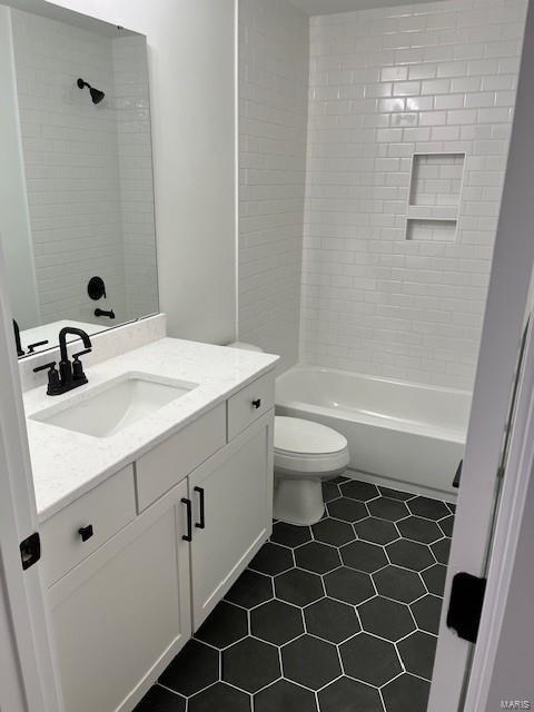 full bathroom with vanity, toilet, tiled shower / bath, and tile patterned flooring