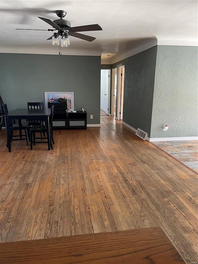 unfurnished dining area featuring wood-type flooring and ceiling fan