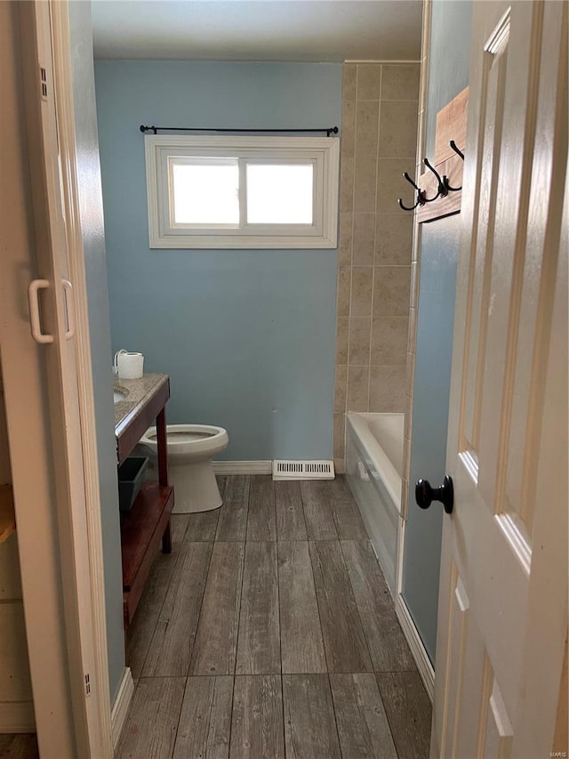 bathroom featuring wood-type flooring, vanity, and toilet