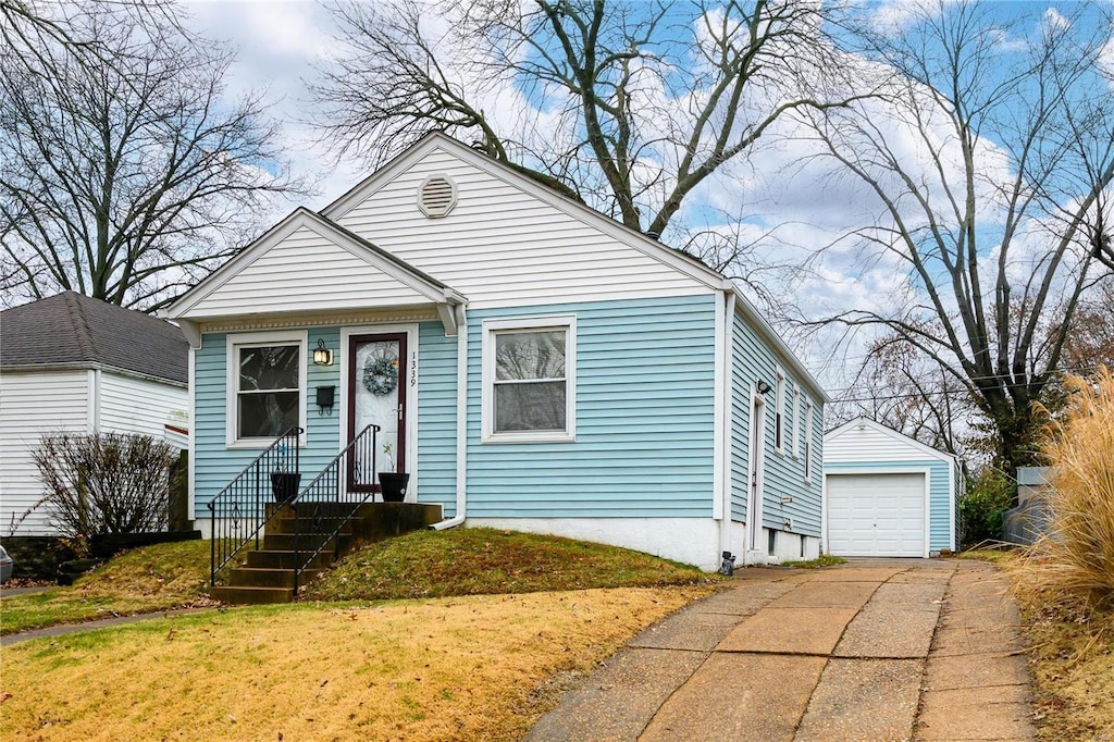 bungalow-style house with an outbuilding, a garage, and a front lawn