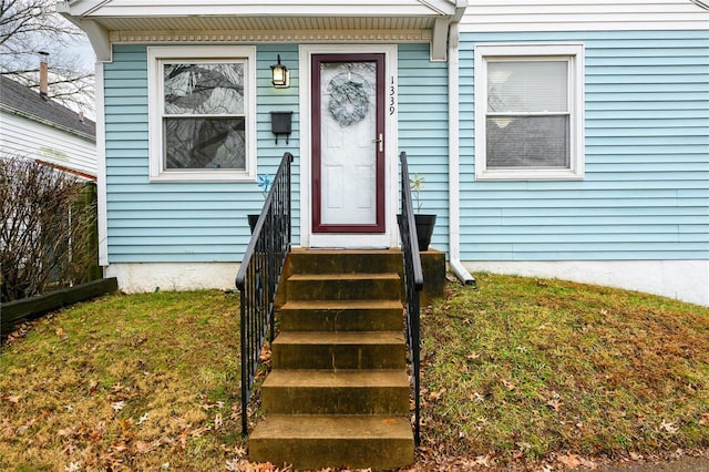 property entrance featuring a lawn