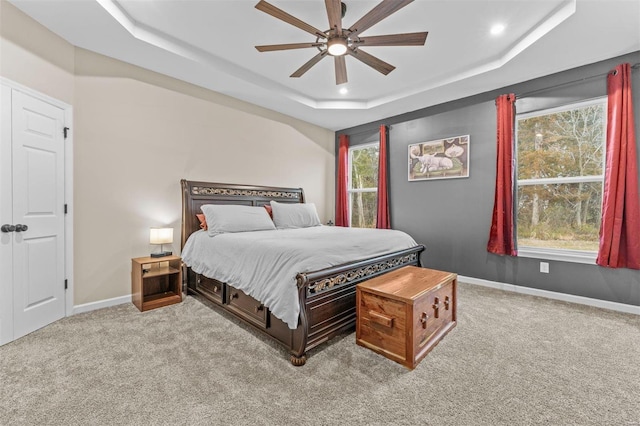 carpeted bedroom featuring ceiling fan, baseboards, a raised ceiling, and recessed lighting