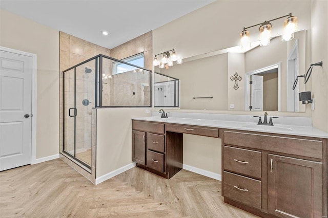 bathroom featuring double vanity, a shower stall, baseboards, and a sink