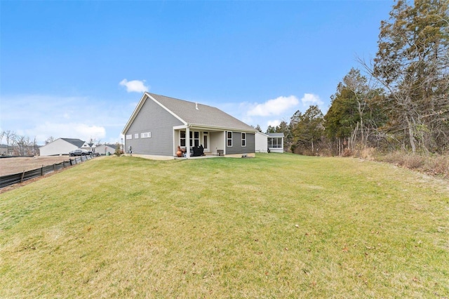 rear view of property featuring a yard, a patio area, and fence