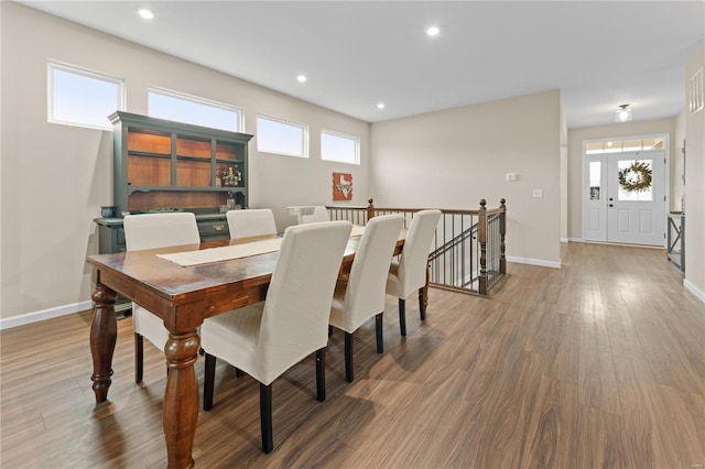 dining space with baseboards, wood finished floors, and recessed lighting