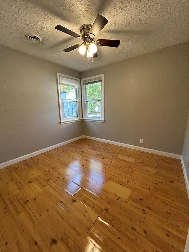 spare room featuring ceiling fan, a textured ceiling, and light wood-type flooring